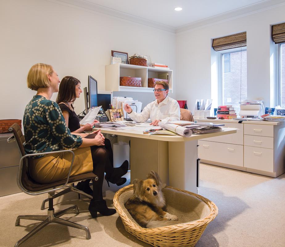 Skip Sroka meets with his staff—and dog, Lucky—in his office. 